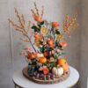 A wood log with pumpkin and chocolate fresh flowers shop online